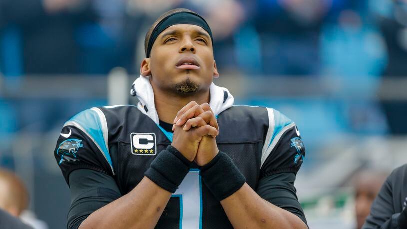 Carolina Panthers quarterback Cam Newton prays along the sideline