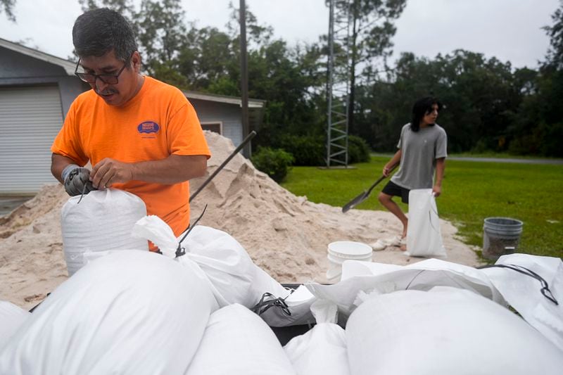 Jose Gonzales and his son Jadin Gonzales, 14, fill sand bags ahead of Hurricane Helene, expected to make landfall Thursday evening, Thursday, Sept. 26, 2024, in Clyattville, Ga. (AP Photo/Mike Stewart)