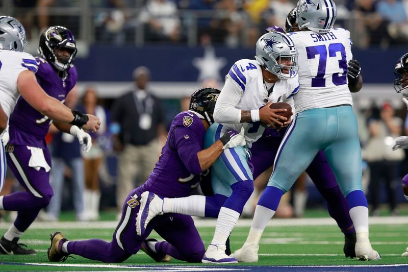 Baltimore Ravens linebacker Kyle Van Noy, left, sacks Dallas Cowboys quarterback Dak Prescott (4) in the first half of an NFL football game in Arlington, Texas, Sunday, Sept. 22, 2024. (AP Photo/Gareth Patterson)