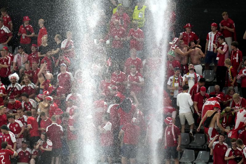 Heavy rain falls on the pitch after the referee paused the match due to a thunder and lightning storm during the round of sixteen match between Germany and Denmark at the Euro 2024 soccer tournament in Dortmund, Germany, Saturday, June 29, 2024. (AP Photo/Hassan Ammar)
