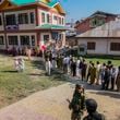 Indian paramilitary soldiers guard as Kashmiris queue up at a polling booth to cast their vote during the final phase of an election to choose a local government in Indian-controlled Kashmir, north of Srinagar, Tuesday, Oct.1, 2024. (AP Photo/Mukhtar Khan)