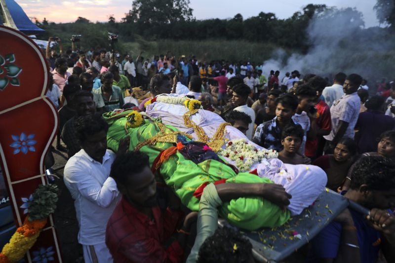 Bodies of a married couple, both of whom died after drinking illegally brewed liquor, are brought for cremation in Kallakurichi district of the southern Indian state of Tamil Nadu, India, Thursday, June 20, 2024. The state's chief minister M K Stalin said the 34 died after consuming liquor that was tainted with methanol, according to the Press Trust of India news agency. (AP Photo/R. Parthibhan)