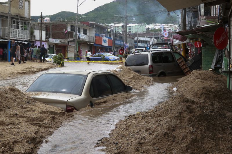 Vehicles are partially submerged on a flooded street in the aftermath of Hurricane John in Acapulco, Mexico, Saturday, Sept. 28, 2024. (AP Photo/Alejandrino Gonzalez)