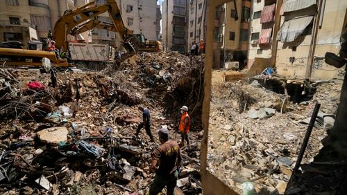 Emergency workers use excavators to clear the rubble at the site of Friday's Israeli strike in Beirut's southern suburbs, Lebanon, Monday, Sept. 23, 2024. (AP Photo/Hassan Ammar)