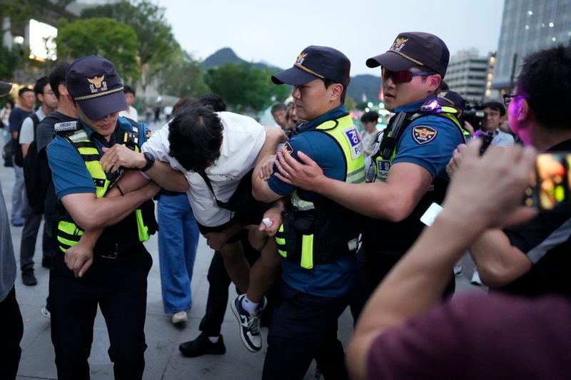 A protester is detained by police officers as he stages a rally opposing the meeting between South Korean President Yoon Suk Yeol and Japanese Prime Minister Fumio Kishida in Seoul, South Korea, Friday, Sept. 6, 2024. (AP Photo/Lee Jin-man)