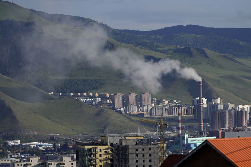 A power plant churns out smoke near residential buildings on the outskirts of Ulaanbataar, Mongolia, Thursday, June 27, 2024. The city has some of the worst air in the world. Annual levels of fine, inhalable particles known as PM2.5 surpass levels considered safe by the World Health Organization by nearly 9-times. Children are particularly at risk. (AP Photo/Ng Han Guan)
