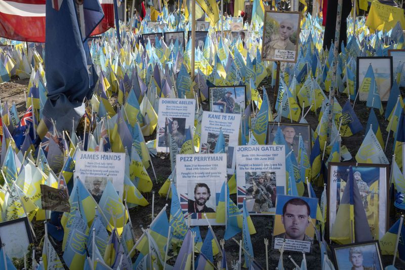 Flags with names of killed international volunteers are carried during Ukrainian Independence Day on Independence Square in Kyiv, Ukraine, Saturday, Aug. 24, 2024. (AP Photo/Efrem Lukatsky)