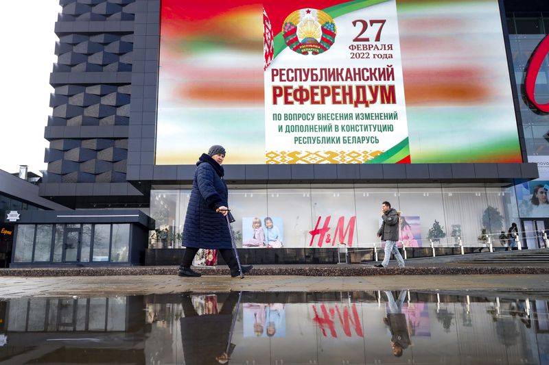 FILE - A woman walks past a poster that reads "Referendum on constitutional amendments" in Minsk, Belarus, on Feb. 18, 2022. (AP Photo, File)