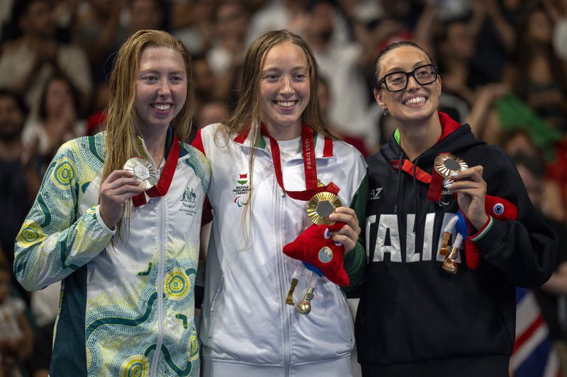 Paralympic athletes Sofia Kankoly of Hungary, centre, Lakeisha Patterson of Australia, left, and Vittoria Bianco of Italy pose at the podium of the women's 400m freestyle -S9, during the 2024 Paralympics, Thursday, Aug. 29, 2024, in Paris, France. (AP Photo/Emilio Morenatti)