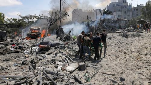 FILE - Palestinians evacuate a body from a site hit by an Israeli bombardment on Khan Younis, southern Gaza Strip, on July 13, 2024. Israel said it targeted Hamas' military commander Mohammed Deif in a massive strike Saturday. (AP Photo/Jehad Alshrafi, File)