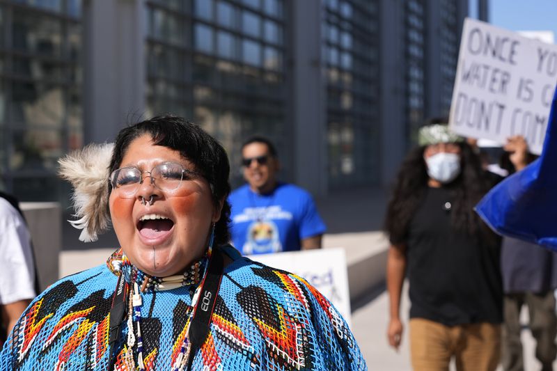 Zoe Perry shouts as she joins other members of the Hualapai Tribe as they march in front of U.S. District Court to try to persuade a federal judge to extend a temporary ban on exploratory drilling for a lithium project Tuesday, Sept. 17, 2024, in Phoenix. (AP Photo/Ross D. Franklin)