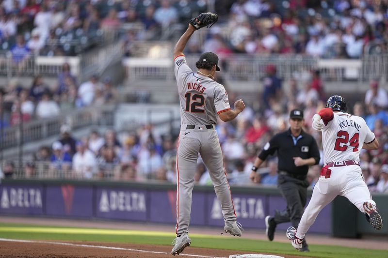 San Francisco Giants'Jordan Hicks (12) tags out Atlanta Braves' Jarred Kelenic (24) on first base in the first inning of a baseball game, Wednesday, July 3, 2024, in Atlanta. (AP Photo/Brynn Anderson)
