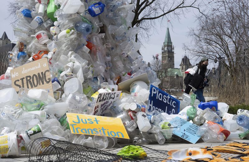 FILE - A person walks past an art installation outside a United Nations conference on plastics on April 23, 2024, in Ottawa, Ontario. (Adrian Wyld/The Canadian Press via AP, File)