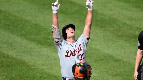 Detroit Tigers' Kerry Carpenter, top, celebrates after his home run in front of Baltimore Orioles catcher Adley Rutschman, bottom, during the sixth inning of a baseball game, Sunday, Sept. 22, 2024, in Baltimore. (AP Photo/Nick Wass)