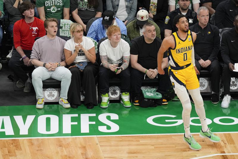 Ed Sheeran, citing at center, watches as Indiana Pacers guard Tyrese Haliburton (0) watches his shot during the first half of Game 2 of the NBA Eastern Conference basketball finals against the Boston Celtics, Thursday, May 23, 2024, in Boston. (AP Photo/Michael Dwyer)