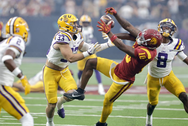 Southern California wide receiver Kyron Hudson (10) pulls in a pass between LSU linebacker West Weeks (33) and safety Major Burns (8) during the first half of an NCAA college football game Sunday, Sept. 1, 2024, in Las Vegas. (AP Photo/Steve Marcus)