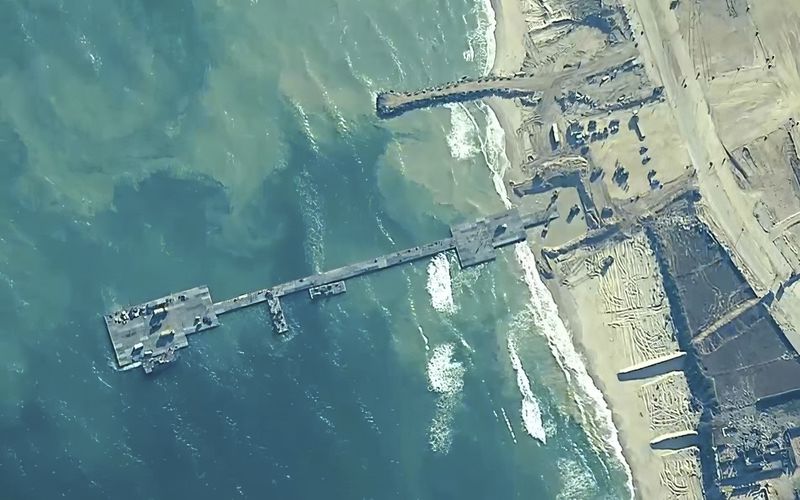 FILE - The image provided by U.S, Central Command, shows U.S. Army soldiers assigned to the 7th Transportation Brigade (Expeditionary), U.S. Navy sailors assigned to Amphibious Construction Battalion 1, and Israel Defense Forces placing the Trident Pier on the coast of Gaza Strip on May 16, 2024. A U.S. built temporary pier that had been used to deliver additional humanitarian aid into Gaza was damaged by rough seas and has temporarily suspended operations. That’s according to three U.S. officials who spoke to The Associated Press on Tuesday. (U.S. Central Command via AP)