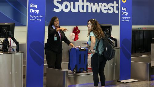 A passenger checks in for her Southwest Airlines flight at Midway International Airport in Chicago, Thursday, July 25, 2024. Southwest Airlines plans to drop the open-boarding system it has used for more than 50 years and will start assigning passengers to seats, just like all the other big airlines. (AP Photo/Teresa Crawford)