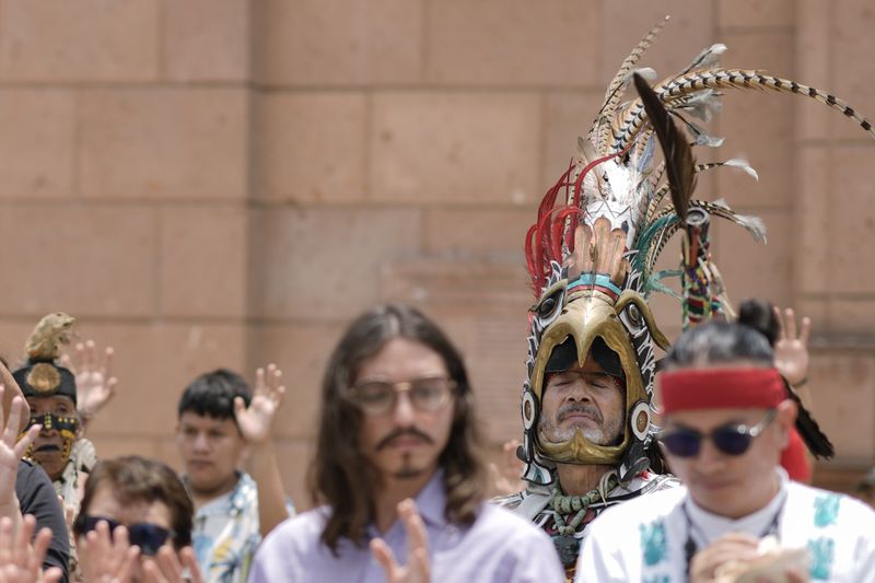 Residents and members of an Amaxac Indigenous organization participate in a ceremony commemorating the 503rd anniversary of the fall of the Aztec empire's capital, Tenochtitlan, in Mexico City, Tuesday, Aug. 13, 2024. (AP Photo/Eduardo Verdugo)