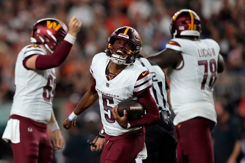 Washington Commanders quarterback Jayden Daniels (5) celebrates after throwing a touchdown pass during the second half of an NFL football game against the Cincinnati Bengals, Monday, Sept. 23, 2024, in Cincinnati. (AP Photo/Carolyn Kaster)