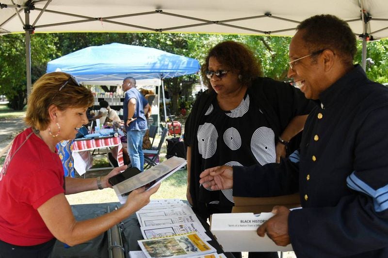 Lonnie Davis (right) shares a copy of his informational booklet “Georgia African Brigade: Slave to Soldier” with an attendee next to his wife Theresa Harvey-Davis (middle) during the 32nd Juneteenth Freedom Festival on Saturday, June 15, 2024, at Tattnall Square Park in Macon, Georgia. Davis does living history presentation on the Georgia African Brigade, three Black Union regiments that organized in Macon during the Civil War. (Photo Courtesy of Katie Tucker)