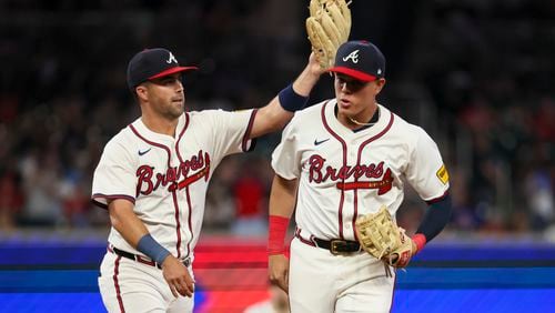 Atlanta Braves second baseman Whit Merrifield, left, celebrates with third baseman Gio Urshela on a double play that ended the top of the eighth inning against the Philadelphia Phillies at Truist Park, Thursday, August 22, 2024, in Atlanta.  (Jason Getz / AJC)