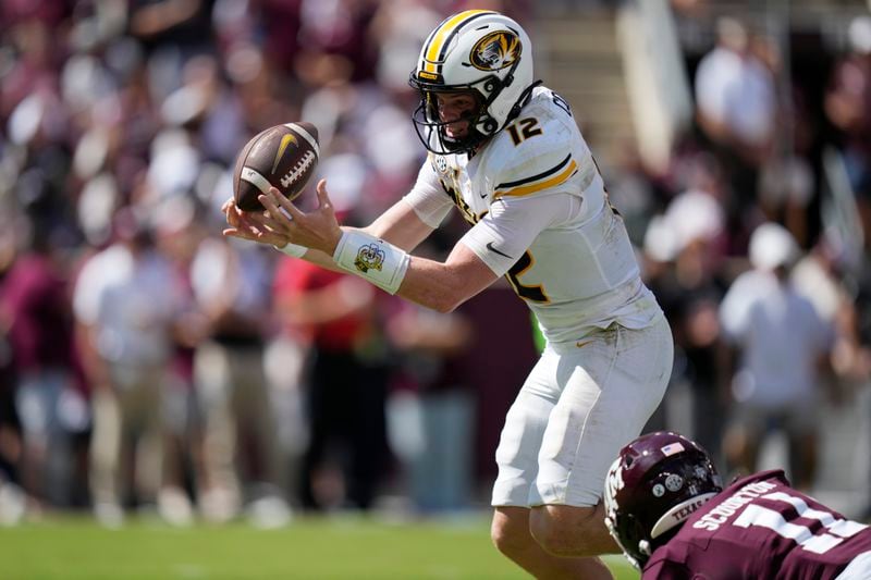 Missouri quarterback Brady Cook (12) is pressured by Texas A&M defensive lineman Nic Scourton (11) during the first half of an NCAA college football game Saturday, Oct. 5, 2024, in College Station, Texas. (AP Photo/Eric Gay)