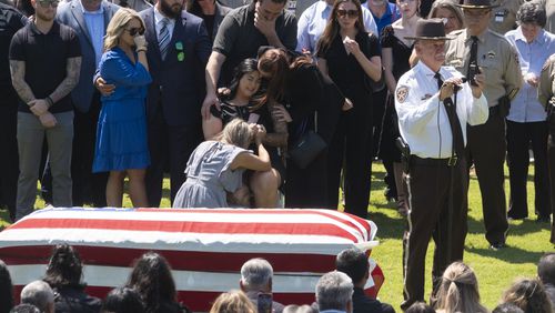 Paulding Sheriff Gary Gulledge holds a radio as the last call is sounded during the funeral for Deputy Brandon Cunningham in Dallas on Friday.   (Ben Gray / Ben@BenGray.com)