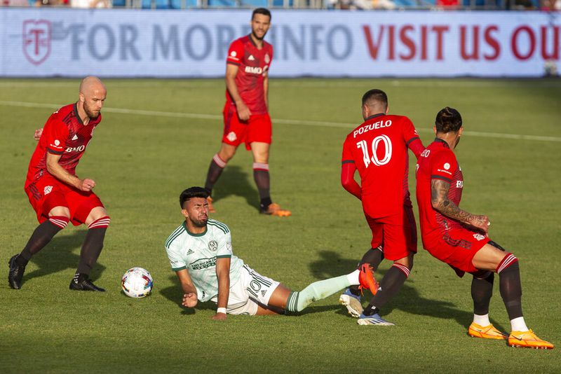 Atlanta United midfielder Marcelino Moreno, center, is fouled by Toronto FC midfielder Alejandro Pozuelo (10) during the first half of an MLS soccer match Saturday, June 25, 2022, in Toronto. (Chris Young/The Canadian Press via AP)