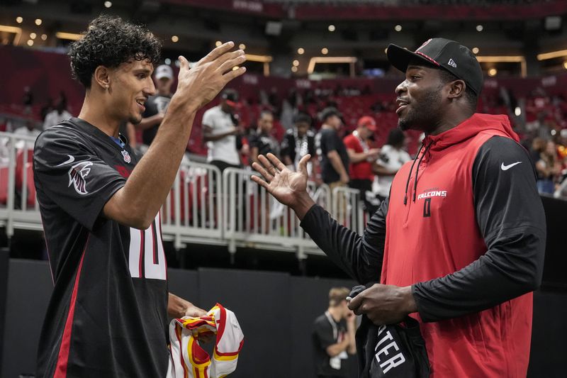 Atlanta Hawks NBA draft pick Zaccharie Risacher, of France, left, speaks with Atlanta Falcons linebacker Lorenzo Carter before an NFL football game between the Atlanta Falcons and the Kansas City Chiefs, Sunday, Sept. 22, 2024, in Atlanta. (AP Photo/Brynn Anderson)