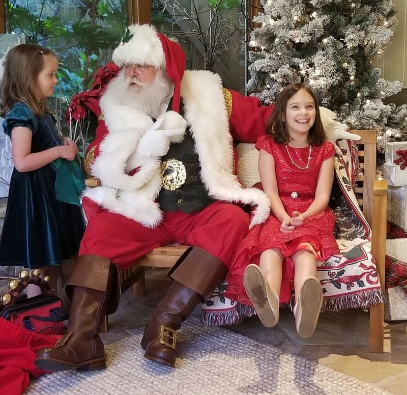 Marian  Dudley (red dress) and Evelyn (green dress), the daughters of Denice and Phillip Dudley, recently went to an outdoor Santa visit in their neighborhood. (Submitted photo)