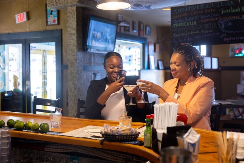 Bria (left) and her mother Dawn Murray enjoy a cocktail at Steamhouse Lounge in Atlanta on Thursday.  The restaurant has just reopened after being closed for five days following several broken water pipes in the city.  (Arvin Temkar/AJC)