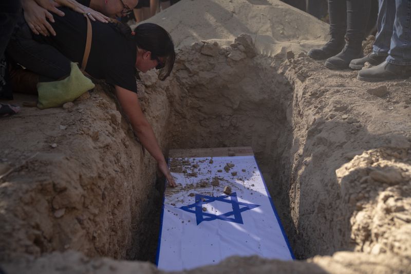 Rimon Buchshtab mourns during the funeral of her husband Yagev Buchshtab at a cemetery of the kibbutz Nirim, southern Israel, Wednesday, Aug. 21, 2024. Buchshtab's body was one the six bodies of hostages, taken in Hamas' Oct. 7 attack, recovered by Israel's military during an operation in the Gaza Strip. (AP Photo/Leo Correa)