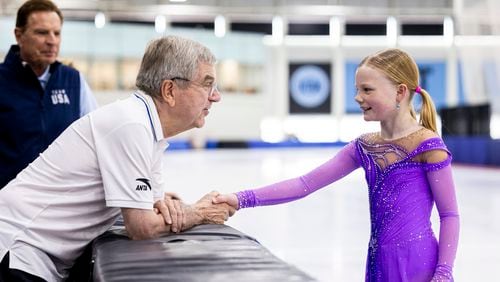 International Olympic Committee President Thomas Bach shakes hands with figure skater Annabelle Atkinson, 10, of Salt Lake City, as they talk at the Utah Olympic Oval in Kearns, Utah, Saturday, Sept. 28. 2024. (Isaac Hale/The Deseret News via AP)