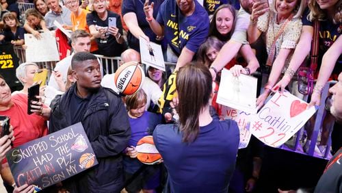 Indiana Fever guard Caitlin Clark (22) signs autographs after warm-ups before the game against Atlanta Dream at State Farm Arena, Monday, August 26, 2024, in Atlanta. 
(Miguel Martinez / AJC)