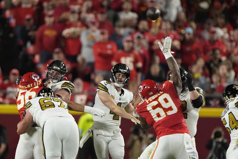 New Orleans Saints quarterback Derek Carr (4) throws over Kansas City Chiefs nose tackle Mike Pennel (69) during the first half of an NFL football game Monday, Oct. 7, 2024, in Kansas City, Mo. (AP Photo/Charlie Riedel)