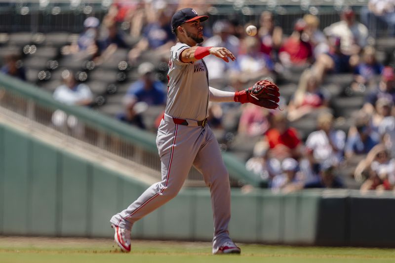 Washington Nationals second baseman Luis García Jr. throws Atlanta Braves' Matt Olson out at first base in the third inning of a baseball game, Sunday, Aug. 25, 2024, in Atlanta. (AP Photo/Jason Allen)