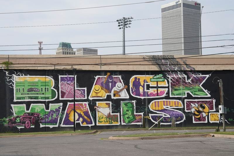 A mural memorializing a once-thriving "Black Wall Street" is displayed in Tulsa, Okla., on Tuesday, July 16, 2024. (AP Photo/Mary Conlon)