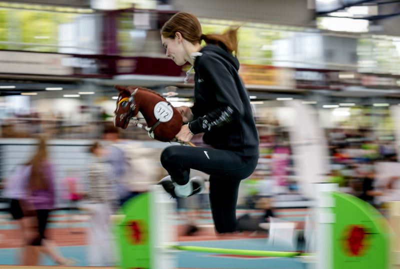 A participant clears the bar during the first German Hobby Horsing Championship in Frankfurt, Germany, Saturday, Sept. 14, 2024. (AP Photo/Michael Probst)