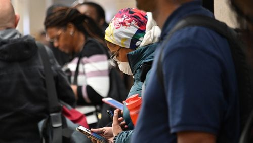 A Marta customer wearing a mask waits for a train during an afternoon rush hour at the Five Points MARTA station in March. Those who rely on mass transit may face a higher risk of exposure to the coronavirus, a factor that disproportionately affects low-income and minority residents in Georgia. (Hyosub Shin / Hyosub.Shin@ajc.com)