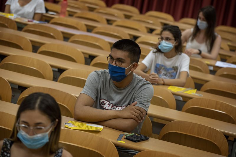 Students wearing face masks sit at their desks keeping social distance, ahead of a selectivity exam at the Autonomous University of Barcelona on Tuesday, July 7, 2020 in Sabadell, outside Barcelona, Spain. (AP Photo/Emilio Morenatti)