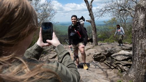 Grayson Cross takes a photo of her husband Zach Cross as his mom Jody approaches on the top of Springer Mountain at the Southern terminus of the Appalachian Trail on Monday just before he started his Appalachian Trail thru-hike.  (Ben Gray / Ben@BenGray.com)