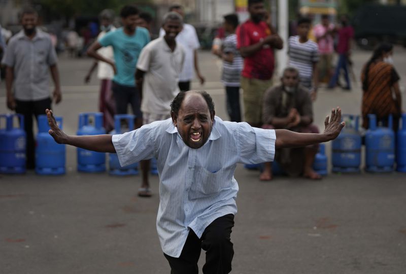 A man shouts slogans demanding cooking gas cylinders as a group of people block an intersection protesting against shortages of essentials in Colombo, Sri Lanka, Saturday, May 7, 2022. (AP Photo/Eranga Jayawardena, File)