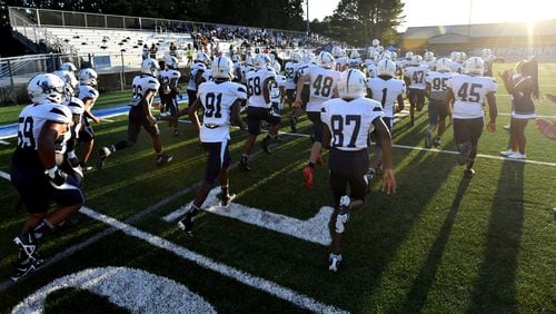 August 26 , 2022 Norcross - South Gwinnett players run onto the football field before their football game against Meadowcreek at Meadowcreek High School in Norcross on Friday, August 26, 2022. (Hyosub Shin / Hyosub.Shin@ajc.com)