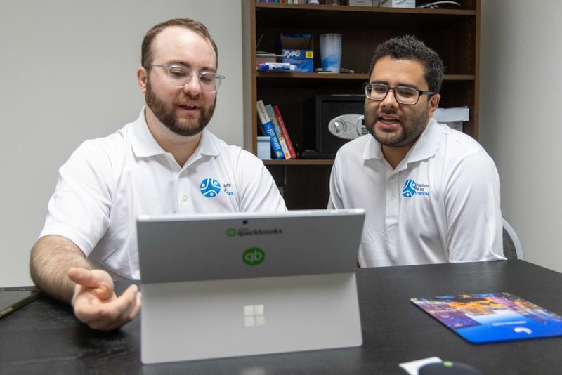 Sam McVay (left) and Miguel Hernandez talk in their office at the Institudo de las Americas.  PHIL SKINNER FOR THE ATLANTA JOURNAL-CONSTITUTION