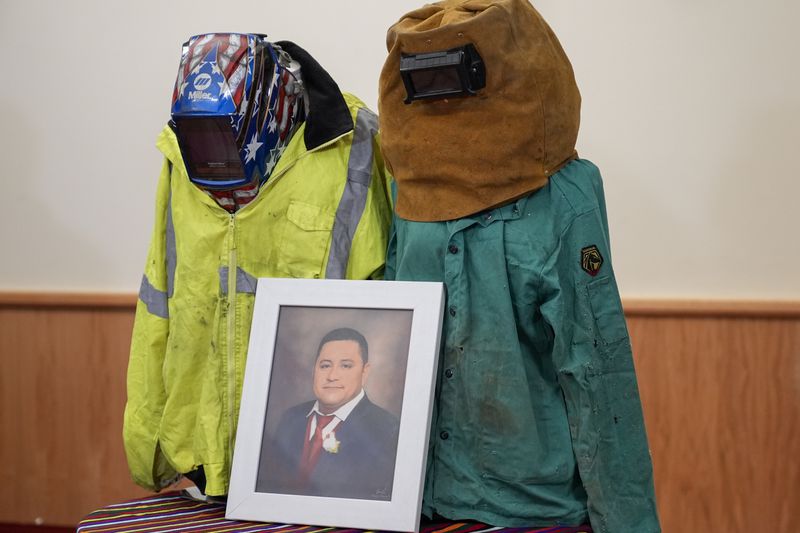 A portrait of Miguel Luna, a worker who died during the collapse of Baltimore's Francis Scott Key Bridge, is displayed among articles of his welding gear, Tuesday, Sept. 17, 2024, during a press conference in Baltimore. (AP Photo/Stephanie Scarbrough)