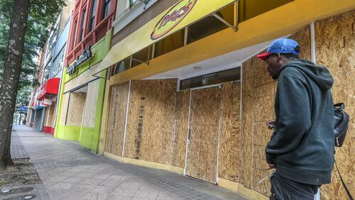 June 1, 2020 Atlanta: Businesses along Peachtree Street across from Woodruff Park were all boarded up Monday morning after losing glass to vandals. Atlantans coming into downtown for work on Monday, June 1, 2020 saw boarded up buildings and debris strewed across sidewalks and streets following weekend cleanup efforts. Over the weekend vandals left a trail of smashed windows and graffiti in their wake. A third day of protests in Atlanta over recent incidents of police violence across the country ended with 64 arrests. According to Atlanta police, the arrests were made without major incidents. A citywide curfew went into effect at 9 p.m. Sunday. JOHN SPINK/JSPINK@AJC.COM