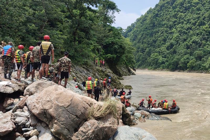 Nepal army personnel cary out a search operation looking for the survivors after two buses were swept by a landslide off the highway and into a swollen river near Simaltal, about 120 kilometers (75 miles) west of the capital Kathmandu, Nepal, Saturday, July 13, 2024. (AP Photo/ Ramesh Paudel)