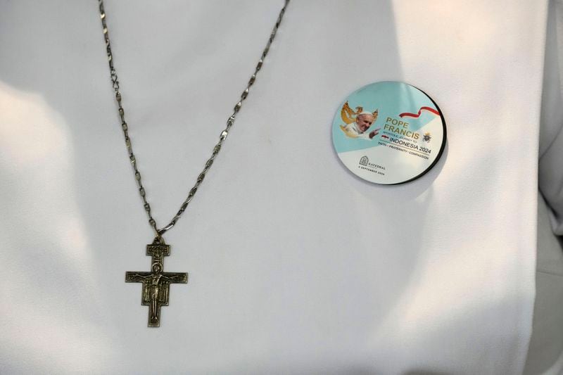 A nun wears a crucifix and a badge showing Pope Francis as she waits for the Pope's arrival in the Cathedral of Our Lady of the Assumption, the capital's main Catholic cathedral, in Jakarta, Indonesia, Wednesday, Sept. 4, 2024. (AP Photo/Dita Alangkara)