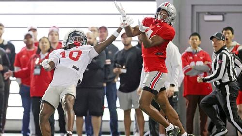 Ohio State University pass-catching prodigy Jeremiah Smith, right, and corner back Jordan Hancock battle for a pass during the NCAA college football team's fan appreciation day workout in Columbus, Ohio, March 29, 2024. (John Kuntz/Cleveland.com via AP)/Cleveland.com via AP)